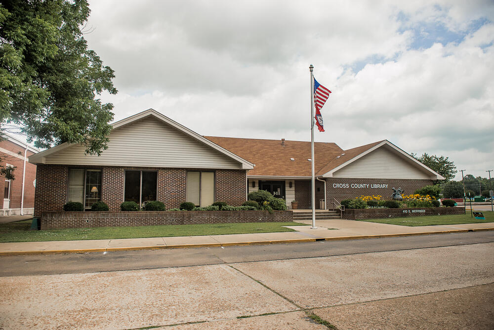 Cross county library with the american flag on a flagpole